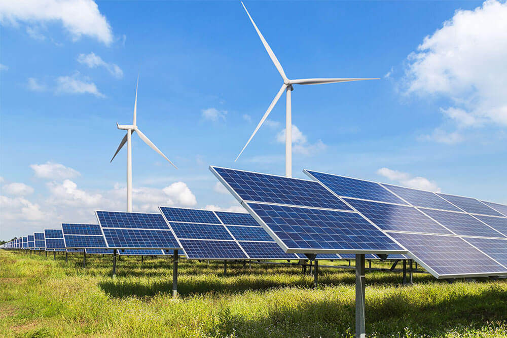 solar panels and wind turbines against a blue sky