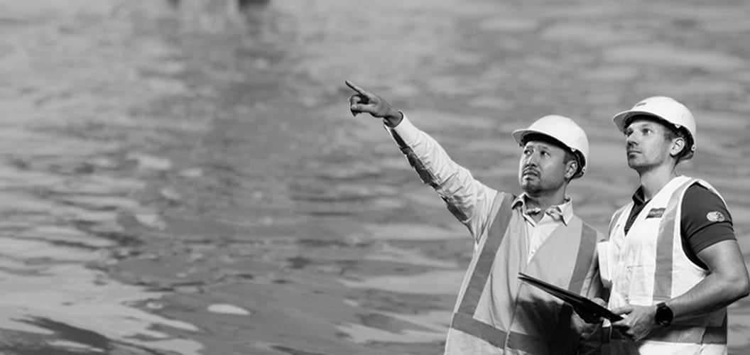 two people looking into the distance with water in the background