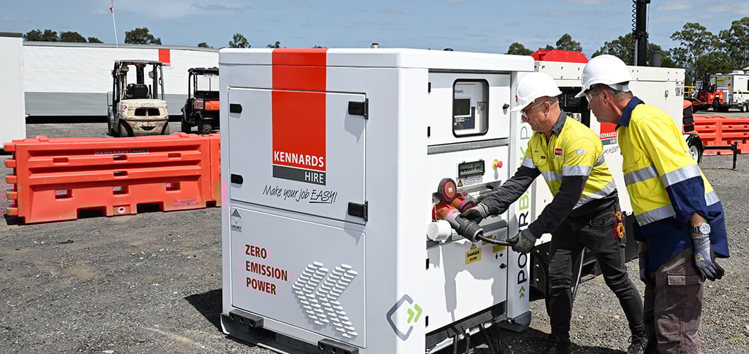 Two people setting up a large generator